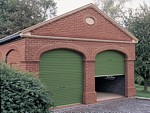 Green roller shutter doors in arched openings